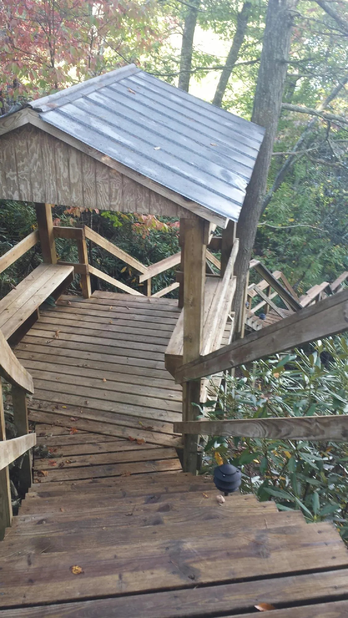 Metal roofed shelter over wooden steps on a wooded walkway — Skylight Repair & Installation work by our crew in Limerick