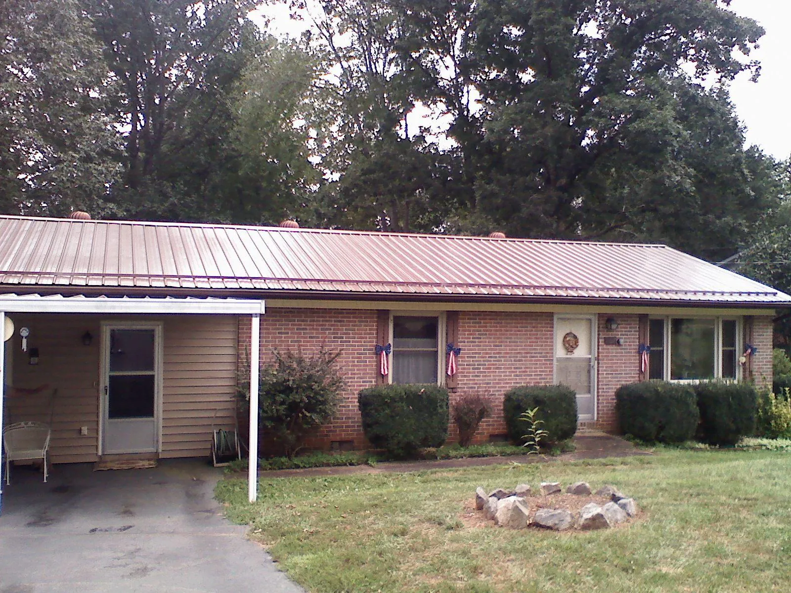 Bronze metal roof and carport on a brick ranch home — Roof Repair work by our crew in Limerick